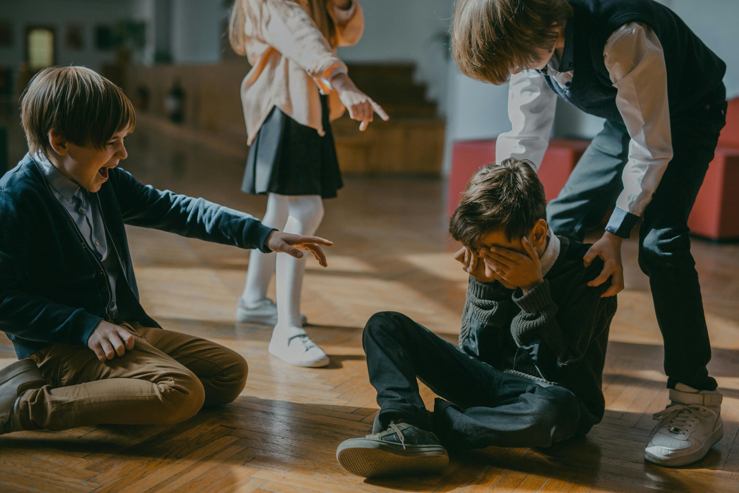 Group of kids bullying another child at school, signaling peer pressure and harassment.